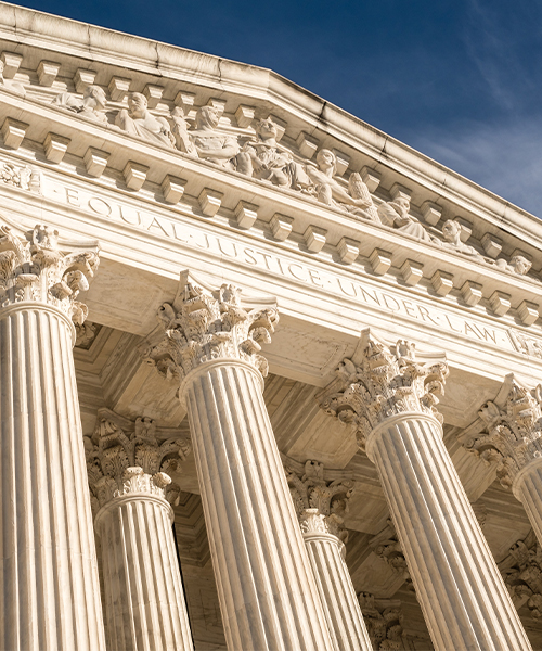 Close-up view of a courthouse with tall columns and the inscription 'Equal Justice Under Law' at the top.